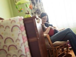 Stephanie Watts sits in her daughters nursery rocking her to sleep