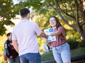 Jocelyn Florez hands out healthcare pamphlets on campus